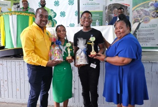 Executive Director, Jamaica 4-H Clubs, Peter Thompson (left) and Parish Manager, St. Mary 4-H Clubs, Halova Stubbs-Jones (right), present trophies and prizes to the Girl of the Year, Nickelia Ramdon of St. Mary High School and Boy of the Year,  Kymani Parkins of St. Mary Technical High.  Occasion was the St. Mary 4-H Clubs’ Parish Achievement Expo, held recently at the St. Mary High School grounds.

