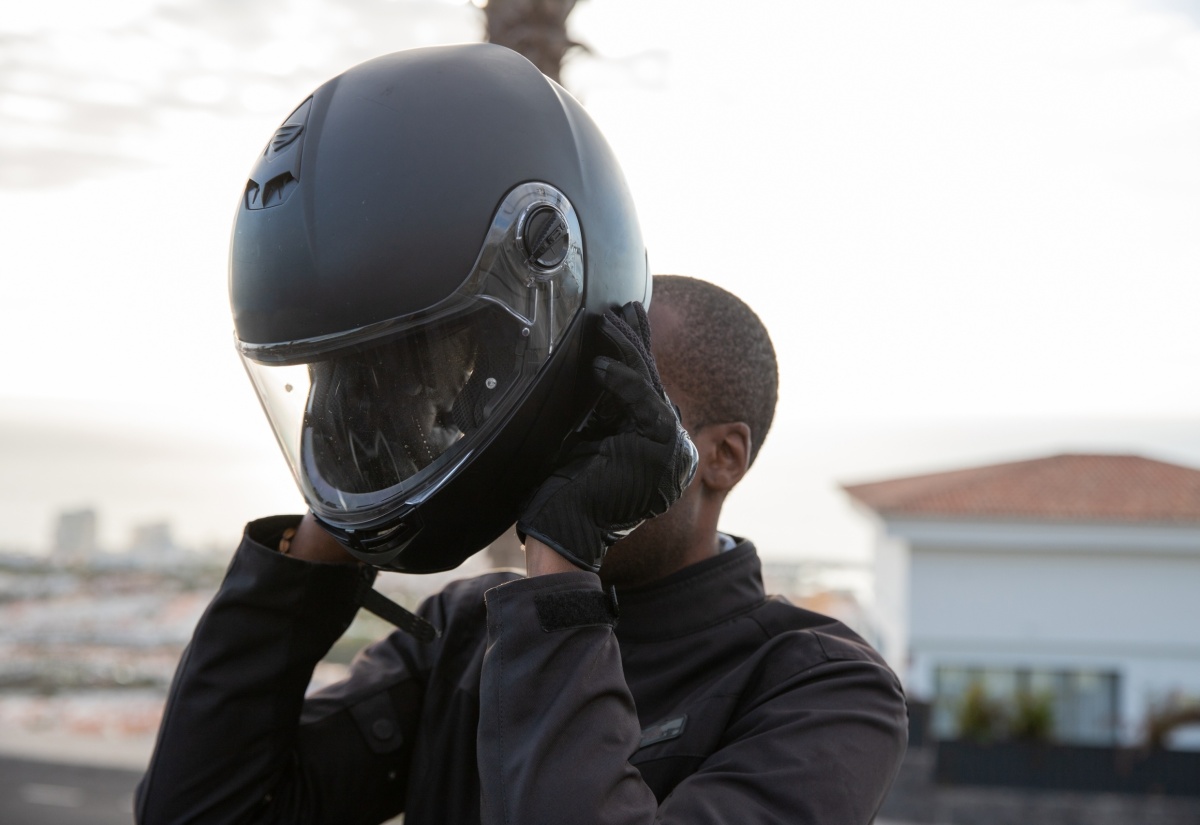 A motorcyclist puts on his helmet 