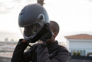 A motorcyclist puts on his helmet 