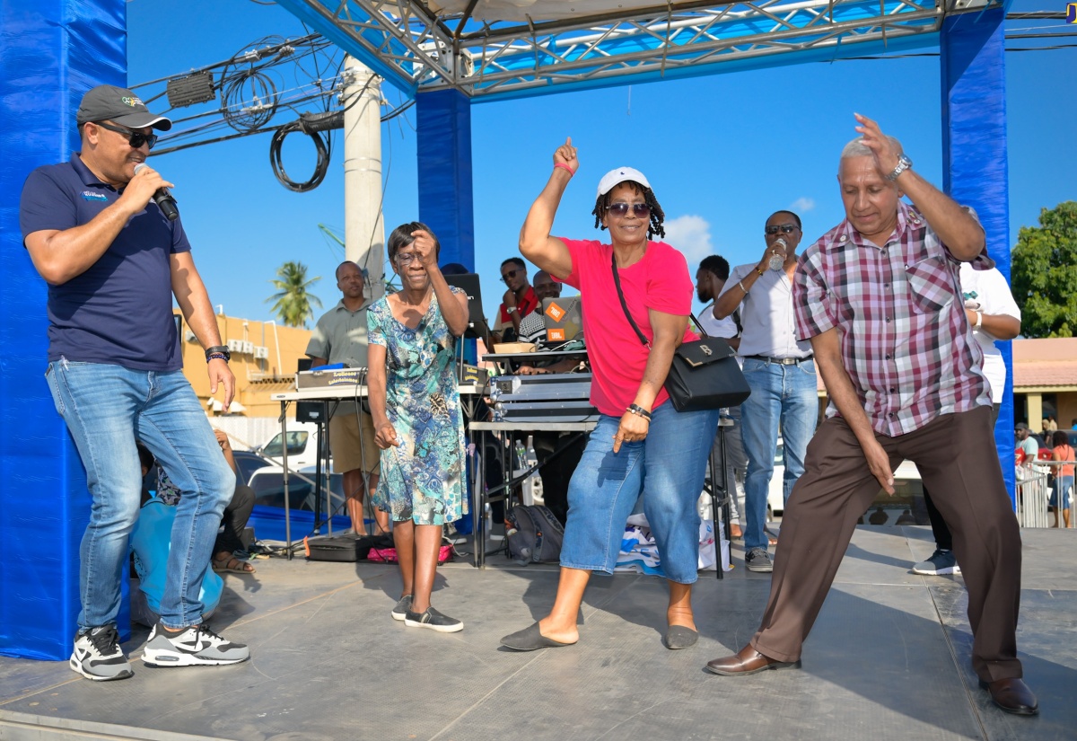 Minister of Health and Wellness, Dr. the Hon. Christopher Tufton (left), ‘adjudicates’ in a ‘dance-off’ involving Councillor for the Rocky Point Division in Clarendon, Winston Maragh (right), and two residents of the parish capital, May Pen, during the Health Ministry’s #KnowYourNumbers campaign roadshow on Friday (May 17). The event was held at Bargain Village Plaza in May Pen.