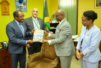 Minister of Local Government and Community Development, Hon. Desmond McKenzie (second right), presents United States Ambassador to Jamaica, His Excellency Nick Perry (left) with a copy of his sectoral presentation when the Ambassador visited the Minister’s Hagley Park Road offices in Kingston on May 30. Sharing in the moment are Country Representative for the United States Agency for International Development (USAID), Dr. Jaidev Singh, and Permanent Secretary in the Ministry, Marsha Henry-Martin.