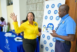 Manager for Marketing and Public Relations at the National Land Agency (NLA), Nicole Hayles (left), speaks with an officer from the Jamaica Constabulary Force, Dwite Thomas, during the launch of the NLA’s ‘Government Employees Mobile Land Information Clinic’, at the Office of the Prime Minister, on Wednesday, May 1.

