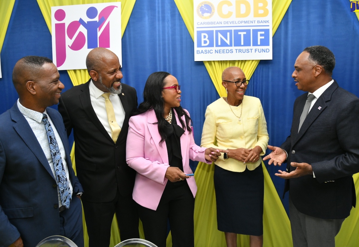 Managing Director, Jamaica Social Investment Fund (JSIF), Omar Sweeney, engages in light conversation with (from left), President of The Mico University College, Dr. Asburn Pinnock; JSIF Board Chairman, Dr. Wayne Henry; Permanent Secretary in the Ministry of Education and Youth, Dr. Kasan Troupe; and Minister of Education and Youth, Hon. Fayval Williams. Occasion was the recent signing of a contract under the Basic Needs Trust Fund (BNTF), to strengthen capacity in special education, held at The Mico campus in Kingston.