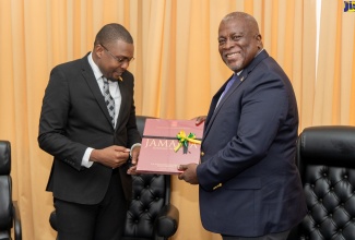 Minister without Portfolio in the Office of the Prime Minister with responsibility for Information, Hon. Robert Morgan (left), presents a book entitled ‘Jamaica: Heritage in Pictures’ to Prime Minister of Guyana, Hon. Brigadier (Ret'd) Mark Phillips. Occasion was a meeting at the Prime Minister’s office in Georgetown on Thursday (May 2).

