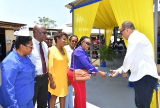 Minister of Health and Wellness, Dr. the Hon. Christopher Tufton (right), and Member of Parliament for St. Catherine Eastern, Denise Daley (second right), cut the ribbon for the official opening of the upgraded waiting area at the Spanish Town Hospital in St. Catherine on Wednesday, May 15.