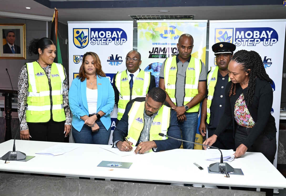 Mayor of Montego Bay and Chairman of the St. James Municipal Corporation, Councillor Richard Vernon (seated), signs the Memorandum of Understanding for the STEP UP programme, during the initiative’s official launch at the Corporation’s chambers on Friday (May 10). Observing (from left) are Chief Executive Officer (CEO) St. James Municipal Corporation, Naudia Crosskill; Lay Magistrates Association of Jamaica (LMAJ) St. James Chapter President, Suzette Ramdanie-Linton; CEO, National Environment and Planning Agency (NEPA), Leonard A. Francis; Regional Operations Manager of WPM Waste Management Limited, Edward Muir; Acting Senior Superintendent of the Jamaica Fire Brigade – St. James, Raymond Desouza; and Executive Secretary at the St. James Municipal Corporation, Cassandra Watson.