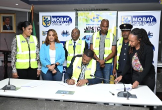 Mayor of Montego Bay and Chairman of the St. James Municipal Corporation, Councillor Richard Vernon (seated), signs the Memorandum of Understanding for the STEP UP programme, during the initiative’s official launch at the Corporation’s chambers on Friday (May 10). Observing (from left) are Chief Executive Officer (CEO) St. James Municipal Corporation, Naudia Crosskill; Lay Magistrates Association of Jamaica (LMAJ) St. James Chapter President, Suzette Ramdanie-Linton; CEO, National Environment and Planning Agency (NEPA), Leonard A. Francis; Regional Operations Manager of WPM Waste Management Limited, Edward Muir; Acting Senior Superintendent of the Jamaica Fire Brigade – St. James, Raymond Desouza; and Executive Secretary at the St. James Municipal Corporation, Cassandra Watson.