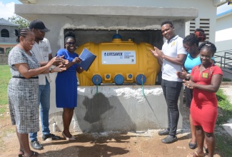 Staff of the New Hope Primary School in Westmoreland show off a new water purification system that was installed at the institution to provide safe drinking water. Sharing the moment are (from left) Guidance Counsellor, Sophia Bowe-Lewis; Watchman, Elliston Clayton; Acting Principal, Latoya Green-Ruddock; Assistant Cook, Lance Buchanan; Bursar, Delvine Baker-Gordon; and Parent, Avagay Ramsey-Thomas.

