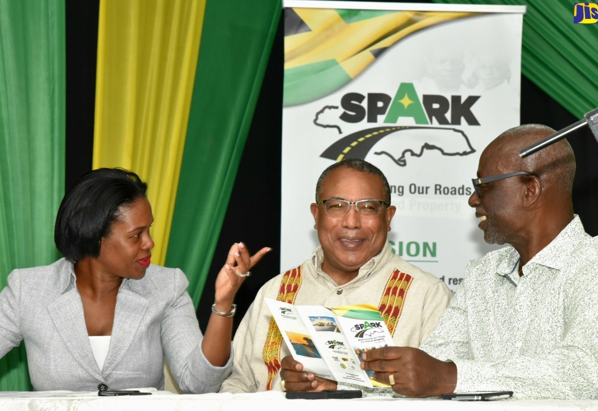 Minister of Local Government and Community Development, Hon. Desmond McKenzie (right), engages with Member of Parliament, St. Andrew Western, Anthony Hylton (centre) and Director, Constituency Development Fund (CDF), Kedesha Rochester, during the first in the series of townhall meetings on the Shared Prosperity through Accelerated Improvement to Our Road Network (SPARK) Programme at the Edith Dalton James High School in Duhaney Park, St. Andrew on May 2.