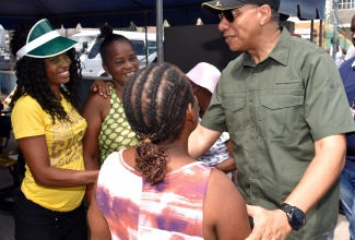 Prime Minister, the Most Hon. Andrew Holness (right), interacting with community members during his visit to the Olympic Gardens Health Centre in Kingston to participate in Labour Day (May 23) activities.