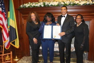 Prime Minister, the Most Hon. Andrew Holness, displays a proclamation made in his honour by the Delaware State Senate in the United States. Mr. Holness was presented with the proclamation during a state dinner hosted in his honour by the Delaware Governor, John Carney, and President of Delaware State University, Dr. Tony Allen, on May 9.  Sharing the moment are (from left) Delaware Majority Leader, Melissa Minor-Brown; Chairwoman, Board of Trustees of Delaware State University, Enid Wallace-Simms, and Delaware State Representative, Sherry Dorsey Walker. 

