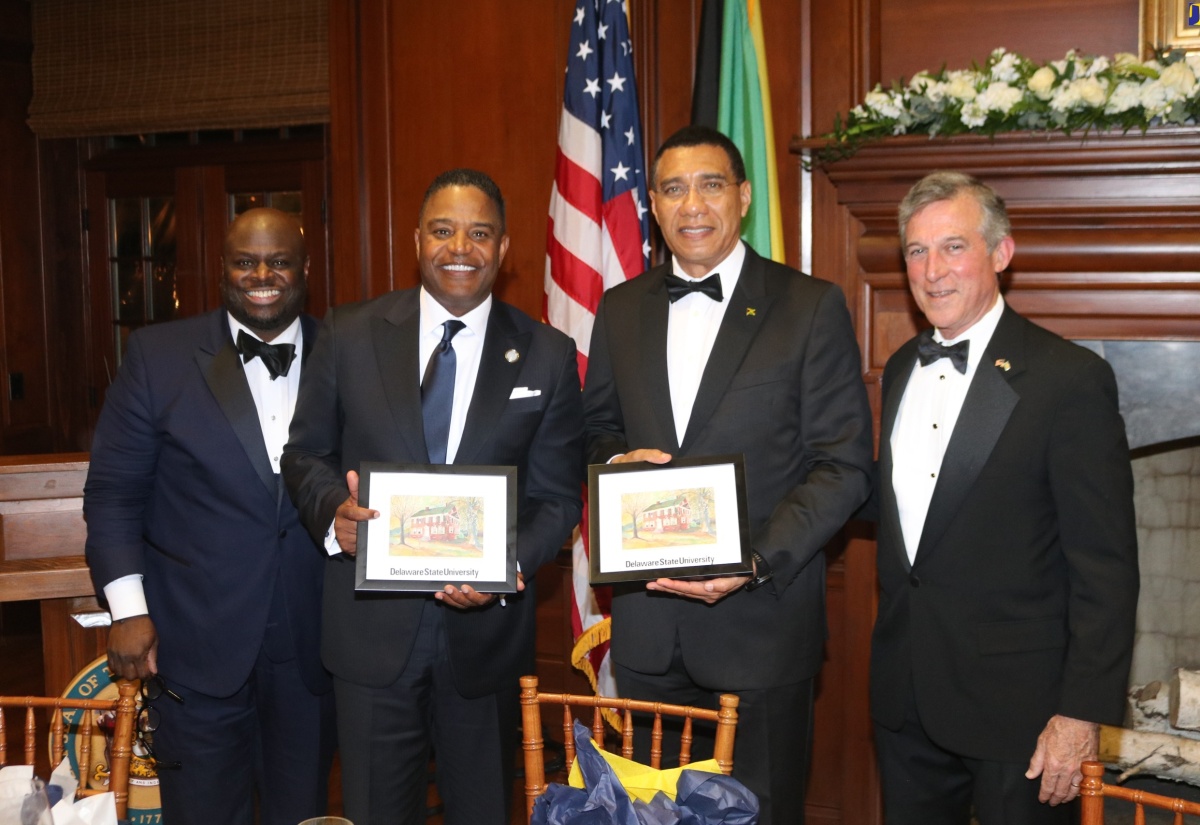 Prime Minister, the Most Hon. Andrew Holness (second right) and Chief Executive Officer of ExxonMobil, Calvin Butler (second left), display artwork of the Delaware State University campus presented to them by President of the University, Dr. Tony Allen (left). Sharing in the occasion is the Governor of Delaware, John Carney.  Occasion was a State dinner held in the Prime Minister’s honour in Delaware in the United States on Thursday night. 