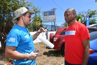 Executive Director, Jamaica Society for the Blind (JSB), Conrad Harris (right), converses with Marketing and Export Manager, EdgeChem Limited, Omar Azan, during the Kingston and St. Andrew Municipal Corporation (KSAMC) Labour Day project at the (JSB) at 111 ½ Old Hope Road in St. Andrew, on Thursday (May 23).