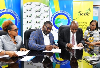 Executive Director, Tourism Product Development Company Limited (TPDCo), Wade Mars (second left) and Executive Director, Jamaica Cultural Development Commission (JCDC), Lenford Salmon (second right), sign a Memorandum of Understanding (MOU) to enhance cultural and tourism training for contestants in the Miss Jamaica Festival Queen competition, at the offices of the TPDCo, on May 30. Witnessing the signing (from left) are Company Secretary, TPDCo, Rosie Carty, and Director, Community Cultural Development Services Division, JCDC, Marjorie Leyden-Kirton.