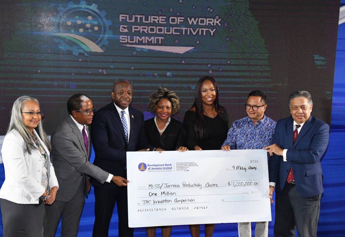 The Jamaica Productivity Centre (JPC) in the Ministry of Labour and Social Security, is presented with a $1 million donation by the Development Bank of Jamaica (DBJ), as a contribution towards the JPC’s various projects to promote productivity. Acting Managing Director, DBJ, David Wan (right), handed over the cheque during the media launch of the Ministry’s Future of Work and Productivity Summit held on May 9 at the University of Technology (UTech) campus in St. Andrew. Accepting the contribution are Permanent Secretary in the Ministry, Colette Roberts Risden (left); State Minister, Dr. the Hon. Norman Dunn (second left); portfolio Minister, Hon. Pearnel Charles Jr (third left); Chief Technical Director, JPC, Tamar Nelson (third right); and JPC Board Chairman, Omar Azan (second right). Sharing the moment is Minister without Portfolio in the Office of the Prime Minister with responsibility for Skills and Digital Transformation, Dr. the Hon. Dana Morris Dixon (centre).

