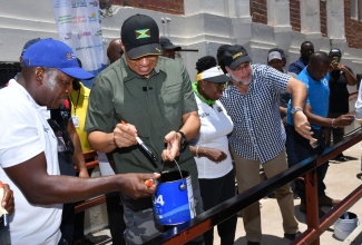 Prime Minister, the Most Hon. Andrew Holness (second left), is joined by (from left) Minister of Labour and Social Security, the Hon. Pearnel Charles, Jr; Minister of Culture, Gender, Entertainment and Sport, Hon. Olivia Grange; Leader of the Opposition, Mark Golding; and Mayor of Kingston, His Worship Councillor Andrew Swaby, in painting the newly installed ramp at the Institute of Jamaica (IOJ), downtown Kingston, on Labour Day, Thursday (May 23). The ramp was built to enhance access to the Institute’s cultural and heritage resources.