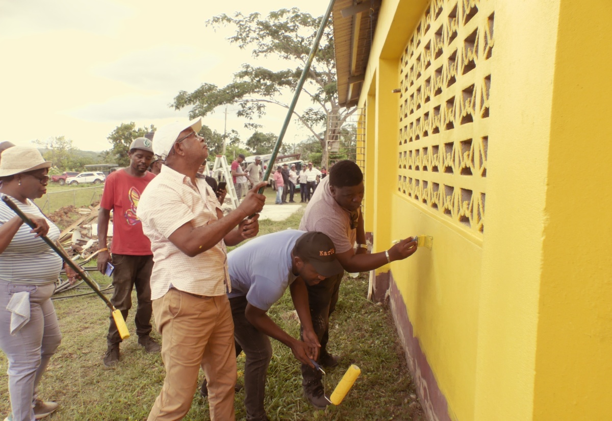 Mayor of Spanish Town, Councillor Norman Scott (second right), joins officers of the St. Catherine Municipal Corporation in painting the exterior walls of the Lluidas Vale Community Centre, during Labour Day activities on Thursday (May 23). The refurbishing of the Community Centre, including the construction of a wheelchair access ramp, was the St. Catherine parish project.