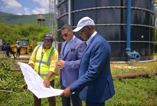Prime Minister, the Most Hon. Andrew Holness (centre); National Water Commission (NWC) Regional Manager for Manchester and St. Elizabeth, Jermaine Jackson (right), and Member of Parliament for St. Elizabeth North Eastern, Delroy Slowley, view several newly installed waterpipes for the Greater Mandeville Water Supply Improvement Project during a visit to the wellsite in Pepper, St. Elizabeth, on Friday (May 17).