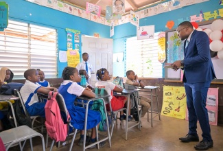 Minister without Portfolio in the Office of the Prime Minister with responsibility for Information, Hon. Robert Morgan, has the attention of grade-four students at the Mocho Primary School in Clarendon as he reads to them during his visit to the institution on Tuesday (May 7) for Read Across Jamaica Day activities.

