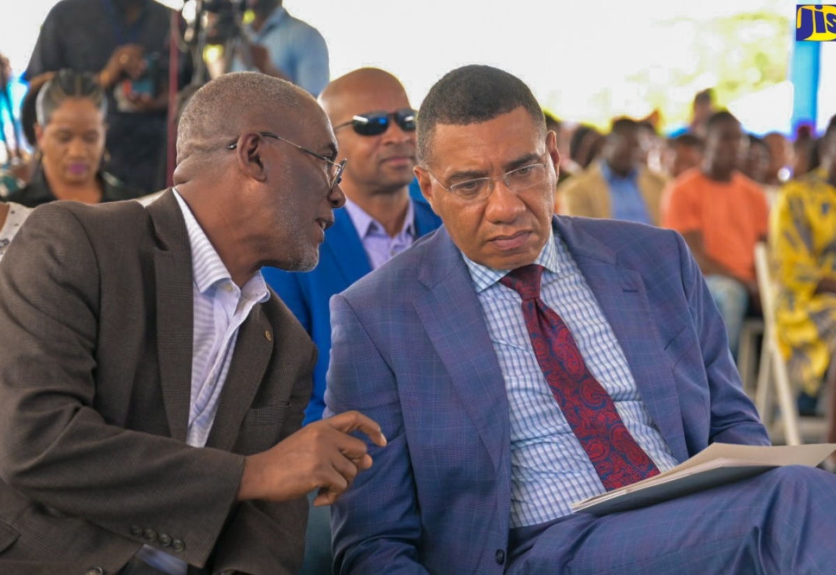 Prime Minister, the Most Hon. Andrew Holness (right), converses with National Housing Trust (NHT) Chairman, Linval Freeman, during the official handover of residential serviced lots under the new Friendship Oaks Phase 1 development in Goshen, St. Elizabeth, on May 17.