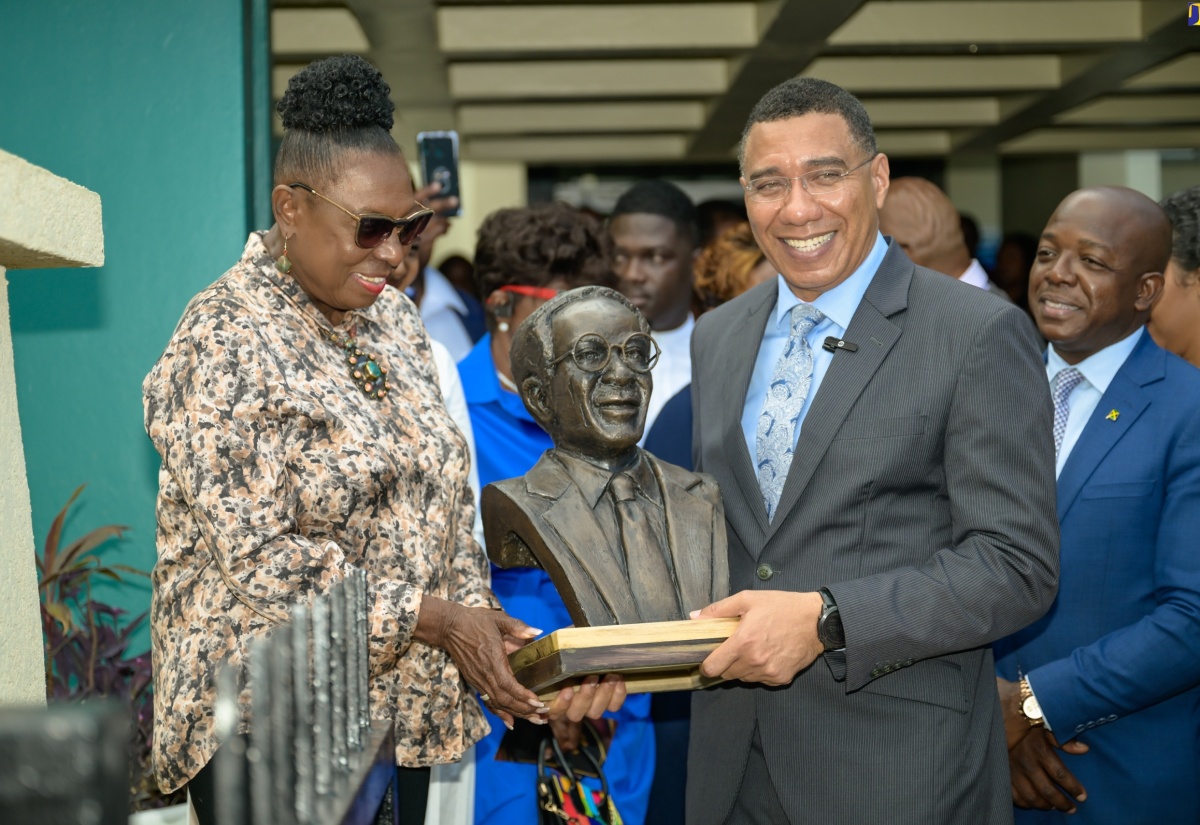 Prime Minister, the Most Hon. Andrew Holness (right), and Minister of Culture, Gender, Entertainment and Sport, Hon. Olivia Grange, hold a replica of the Lynden G. Newland bust. Occasion was the unveiling for the sculpture in honour of the late former Labour Minister, at the Ministry of Labour and Social Security’s National Heroes Circle location in Kingston on May 22. Sharing the moment is Labour and Social Security Minister, Hon. Pearnel Charles Jr.


