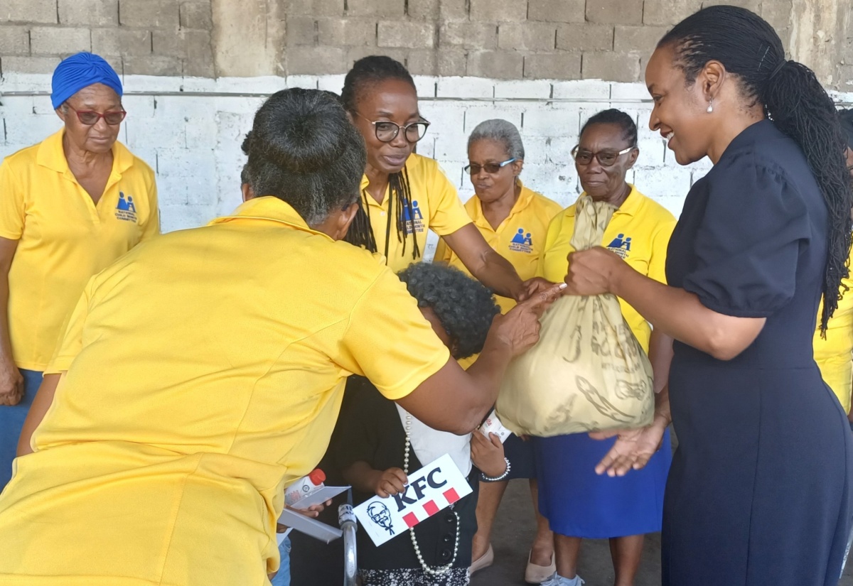 State Minister in the Ministry of Education and Youth, Hon. Marsha Smith (right), participates in the handout of grocery items to children, during the National Child Month Committee (NCMC) Care Package Distribution initiative at the Pentecostal Gospel Temple, 111 Windward Road, Kingston on Friday, May 31.
