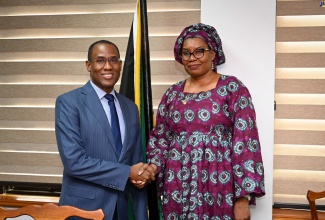 Minister of Finance and the Public Service, Dr. the Hon. Nigel Clarke, greets the Republic of the Gambia’s Secretary-General and Head of the Civil Service, Salimatta Touray, during her courtesy call at the Ministry’s offices in Kingston on Tuesday (June 4). 
