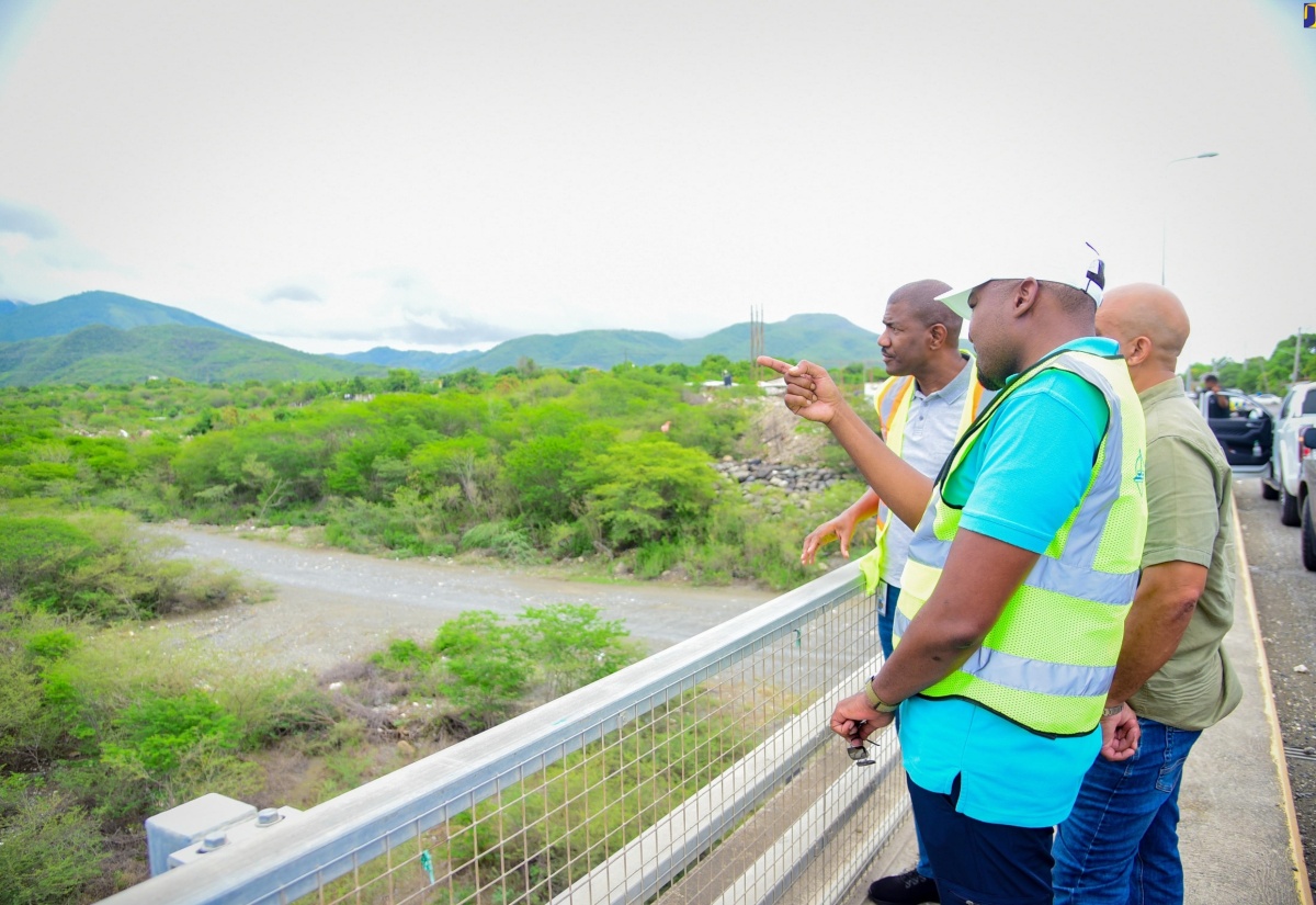 Minister without Portfolio in the Ministry of Economic Growth and Job Creation with Responsibility for Works, Hon. Robert Morgan (foreground), highlights aspects of work along a segment of the Southern Coastal Highway Improvement Project (SCHIP), between Harbour View, St. Andrew and Golden Grove, St. Thomas, to National Works Agency (NWA) Senior Director for Project Implementation, Varden Downer (left), and St. Thomas Western Member of Parliament, James Robertson, during a tour on Friday (June 7). 