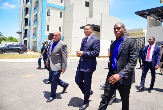 Prime Minister, the Most Hon. Andrew Holness (centre), along with President and Chief Executive Officer of Sagicor Group, Christopher Zacca (left), and Assistant Vice President at the Sagicor Group, Shane Walters (right), tour the New Brunswick Village in Spanish Town, St. Catherine. The mixed housing and commercial development, representing a $6-billion investment by Sagicor, was officially opened on Wednesday (June 19).

