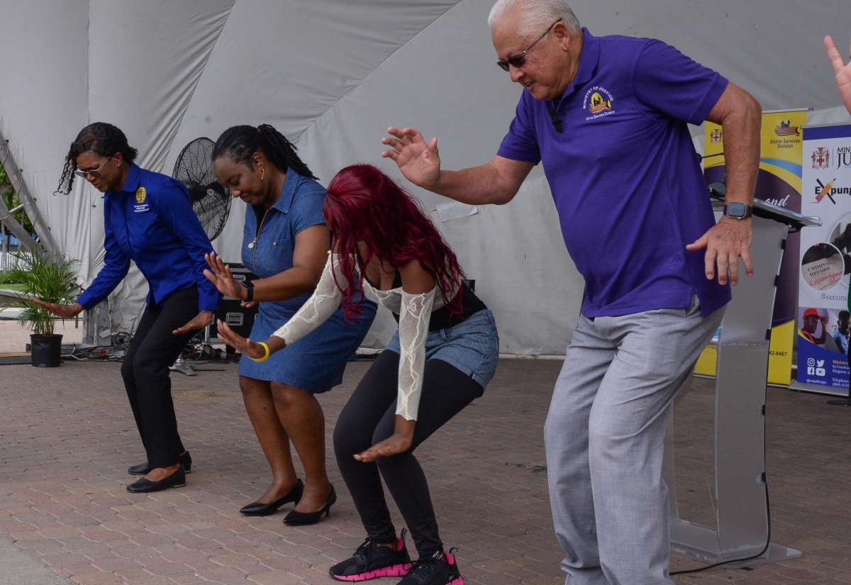 Minister of Justice, Hon. Delroy Chuck (right), demonstrates his dancing skills alongside individuals attending the Legal Aid Council justice fair for persons with disabilities, which was held at Emancipation Park in New Kingston on Friday (June 21).