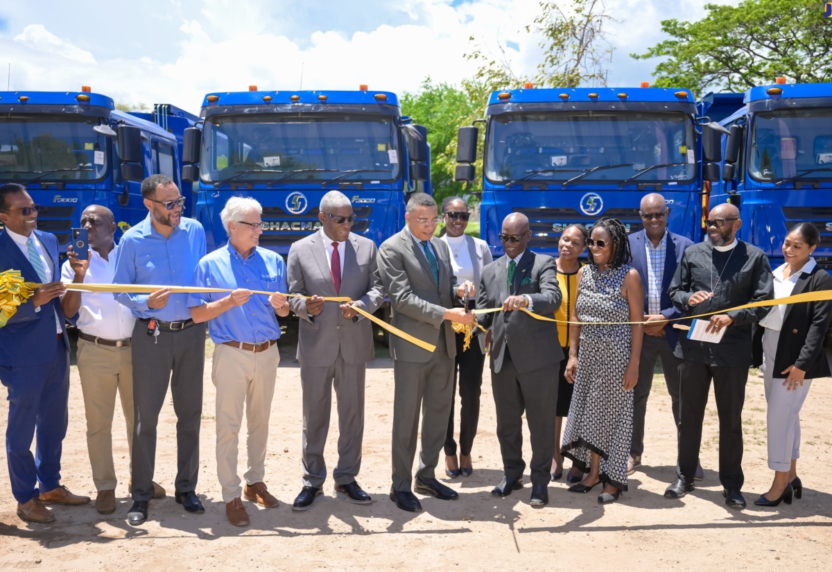 Prime Minister, the Most Hon. Andrew Holness (sixth left), is joined by Minister of Local Government and Community Development, Hon. Desmond McKenzie (sixth right), in cutting the ribbon to officially hand over 50 new trucks to the National Solid Waste Management Authority (NSWMA), at National Heroes Park in Kingston on Tuesday (June 25). Executive Director of the NSWMA, Audley Gordon (second left), and the entity’s new Chairman, Owen Ellington (fifth left) are among those sharing the occasion.