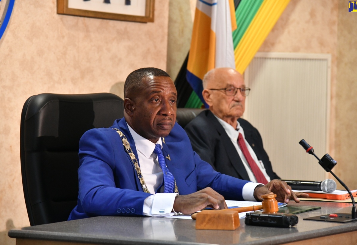 Mayor of Kingston, Councillor Andrew Swaby (left), addresses the Kingston and St. Andrew Municipal Corporation (KSAMC) recent monthly sitting. The meeting was held at the Corporation’s Chambers in downtown Kingston. Beside Councillor Swaby is former Jamaica Olympic Association (JOA) President, Mike Fennell, who was a guest at the sitting.

