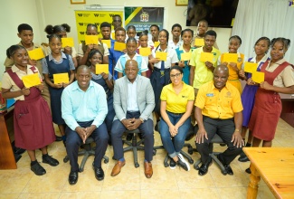 Student beneficiaries of academic grants donated by Jamaican farm workers at Gebbers Farms in Washington, United States, are photographed with (from left, seated)  Supervisor at Gebbers Farms, Eyon Gayle; Minister of Labour and Social Security, Hon. Pearnel Charles Jr., Marketing Manager at GraceKennedy Remittance Services, Ayanna Kirton-Haynes and Director of the Overseas Employment Programme at the Labour Ministry, Delroy Palmer. The handover ceremony was held at the St. Elizabeth Technical High School in Santa Cruz on June 5.