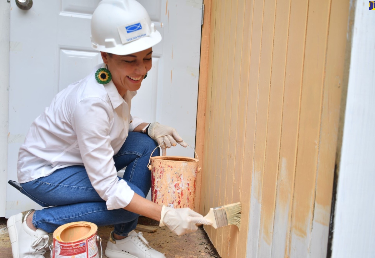 Minister of Foreign Affairs and Foreign Trade, Senator the Hon. Kamina Johnson Smith, paints a section of a house constructed in Chatham, St. James, under the ‘Build A House in One Day’ Project,  which involved a partnership between the United States-based Housing Foundation of America, and Food for the Poor. The project was one of 14 initiatives undertaken across the island for Diaspora Day of Service on Thursday (June 20).  


