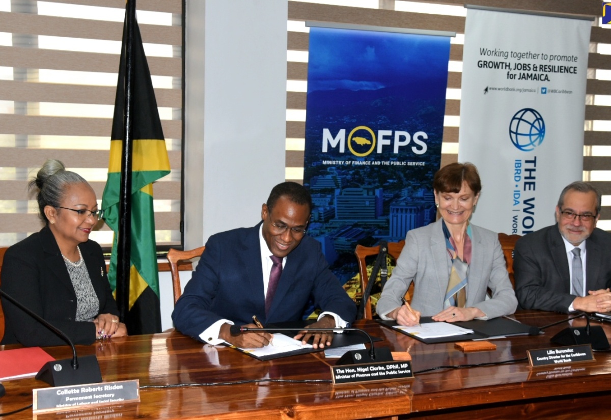 Minister of Finance and the Public Service, Dr. the Hon. Nigel Clarke (second left), and World Bank Country Director, Lilia Burunciuc (second right), sign the US$20million Social Protection for Increased Resilience and Opportunities (SPIRO) Project loan agreement during Tuesday’s (June 11) SPIRO Visibility Ceremony at the Ministry of Finance and the Public Service in Kingston. Observing are (from left) Permanent Secretary in the Ministry of Labour and Social Security, Collette Roberts Risden; and World Bank Human Development Regional Director, Dr. Jaime Saavedra.

