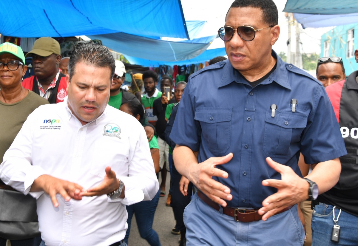 Prime Minister the Most Hon. Andrew Holness (right) and Minister without Portfolio in the Ministry of Economic Growth and Job Creation, Senator the Hon. Matthew Samuda (left), tour a section of the Ocho Rios market in St. Ann on Friday (June 21). The tour formed part of a working visit to the parish by the Prime Minister.