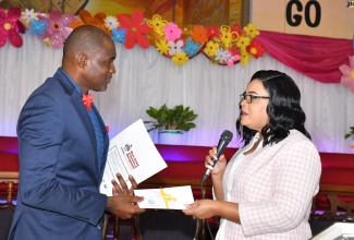Chief Executive Officer of the Child Protection and Family Services Agency, Laurette Adams Thomas (right) presents a cheque for $50,000 to the Pastor, Portmore Seventh- Day Adventist Church, Francis West, which will go towards the children’s ministry at the church. The presentation was made during the CPFSA's 20th Anniversary National Church Service held at the Church in St. Catherine on June 1.