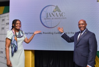 Industry, Investment and Commerce Minister, Senator the Hon. Aubyn Hill (right); and Chief Executive Officer (CEO), JANAAC Global Accreditation, Sharonmae S. Walker,  unveil JANAAC’s new name and logo at the CEO’s Breakfast and Rebranding ceremony staged by the agency on June 11 at The Jamaica Pegasus hotel in New Kingston.

