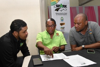 Member of Parliament for St. Mary South Eastern, Dr. Norman Dunn (centre), engages in a conversation with Mayor of Port Maria, Councillor Richard Creary (right), and Constituency Development Fund Programme Management Unit (CDFPMU) Representative, Nackadian Jones, during a Shared Prosperity Through Accelerated Improvement to our Road Network (SPARK) Programme Consultation for the Castleton and Richmond Divisions in St. Mary South Eastern. The consultation was held at Richmond Community Centre in the parish on Thursday (June 6). 