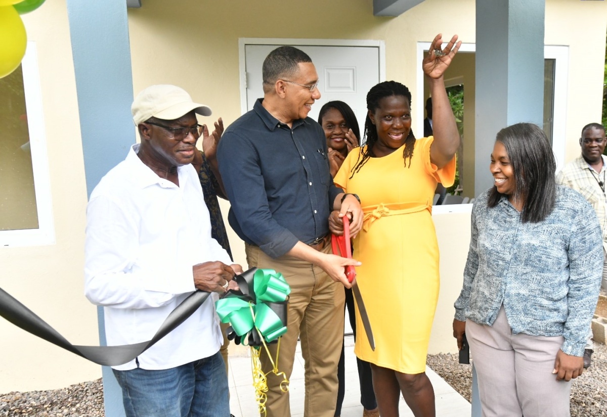 Prime Minister, the Most Hon. Andrew Holness (second left), looks on while new homeowner Cassandra Pryce (second right) proudly displays the keys to her new house in Bartons, St. Catherine, on Friday (June 7), which was provided under the New Social Housing Programme (NSHP). Sharing the moment (from left) are Member of Parliament for St. Catherine South Western, Everald Warmington; and Chairperson of the NSHP Oversight Committee, Judith Robb Walters.