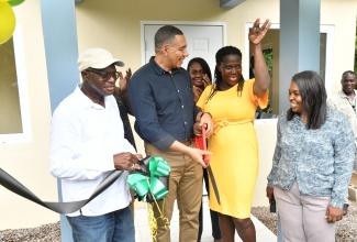 Prime Minister, the Most Hon. Andrew Holness (second left), looks on while new homeowner Cassandra Pryce (second right) proudly displays the keys to her new house in Bartons, St. Catherine, on Friday (June 7), which was provided under the New Social Housing Programme (NSHP). Sharing the moment (from left) are Member of Parliament for St. Catherine South Western, Everald Warmington; and Chairperson of the NSHP Oversight Committee, Judith Robb Walters.