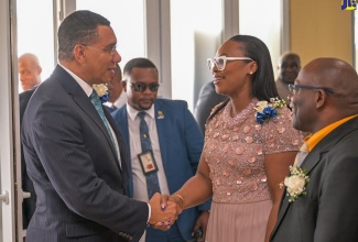 Prime Minister, the Most Hon. Andrew Holness (left), is greeted by President of the Jamaica Civil Service Association (JCSA), Techa Clarke-Griffiths, on his arrival at JACISERA Park, in St. Andrew on May 30, for the Jamaica Civil Service Association (JCSA) 105th annual general meeting. At right is 1st Vice President, JCSA, Clarence Frater.