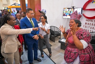Prime Minister, the Most Andrew Holness (second from left), looks on as Minister of State in the Ministry of Foreign Affairs and Foreign Trade, Hon. Alando Terrelonge, points to a life-sized figure of cultural icon Hon. Louise Bennett Coverley, which was on display at the 10th Biennial Jamaica Diaspora Conference on Wednesday (June 18). The four-day conference is being held at the Montego Bay Convention Centre in Rose Hall, St. James.