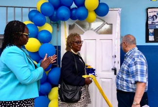 Principal of Ocho Rios Primary School, Suzette Wilson (left), applauds as Custos of St. Ann, Norma Walters (centre), cuts the ribbon for the newly installed computer lab at a ceremony at the school on June 4. At right is Businessman, Kumar Sujanani, who retrofitted the lab.