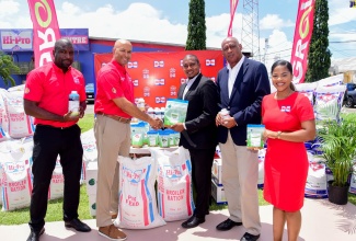 Minister of Agriculture, Fisheries and Mining, Hon. Floyd Green (centre), is presented with agricultural inputs to assist farmers affected by the passage of Hurricane Beryl, by Hi-Pro Vice President, Colonel (Ret'd) Jaimie Ogilvie (second left). Sharing in the presentation (from left) are Hi-Pro Divisional Sales and Distribution Manager, Trevin Nairne; Senior Strategist in the Ministry, Michael Pryce; and Hi-Pro Ace Supercenter Farm Store Manager, Sherrae Wong-Black. Some $5 million in supplies were handed over at Hi-Pro in White Marl, St. Catherine, on Thursday (July 25). 