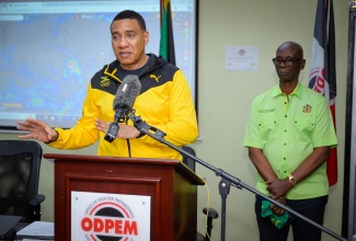Prime Minister, the Most Hon. Andrew Holness, addresses the media during a visit to the National Emergency Operations Centre, located at the Office of Disaster Preparedness and Emergency Management (ODPEM) in Kingston, on Wednesday (July 3). In the background is Minister of Local Government and Community Development, Hon. Desmond McKenzie.

