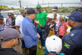 Prime Minister, the Most Hon. Andrew Holness (second left), speaks with residents of Rocky Point, Clarendon,  during a tour of the area on Saturday (July 6), to get a firsthand look at the impact of Hurricane Beryl.