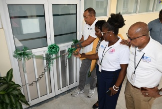 Minister of Health and Wellness, Dr. the Hon. Christopher Tufton (left), cuts the ribbon to officially open a newly renovated operating theatre at the Falmouth Public General Hospital in Trelawny on Friday (July 26). He is joined by (from 2nd left), Parish Manager for Trelawny Health Services, Keriesa Bell Cummings; Chief Executive Officer (CEO) of the Falmouth Public General Hospital, Princess Wedderburn; and Regional Director, Western Regional Health Authority (WRHA), Andrade Sinclair. 