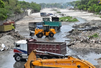 The National Works Agency (NWA) team using heavy equipment to clear the Sandy Gully in the vicinity of Spanish Town Road in Kingston on Tuesday (July 2), ahead of the passage of Hurricane Beryl.