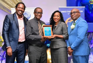 State Minister in the Ministry of Education and Youth, Hon. Marsha Smith (second right), presents the Jamaica Teachers’ Association (JTA) Golden Torch Award to Earle Fyffe (second left), for 46 years of service to education. Sharing in the presentation (from left) are Opposition Spokesperson on Education, Senator Damion Crawford; and JTA President, Leighton Johnson. The awards ceremony was held on Friday (July 12) at the Jamaica Pegasus Hotel in New Kingston.